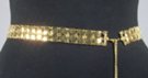 gold chain belt made of 29 inches of 1 inch wide mesh of small convex plates and 14 inches of chain with heart at tip