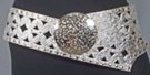 3" textured wide belt with rivets and cut-outs; 3.5" circular distressed metal buckle; rides low on hips with extra long overhang