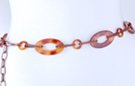 chain belt: alternating amber ovals and rings joined by copper flat chain; extension chain comprises stippled bronze links tipped with amber ring