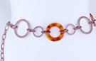 chain belt: big amber and bronze rings alternate with smaller bronze circles, all joined by swirled bronze chain links; extension chain comprises smaller stippled bronze links with tiny amber ring at tip