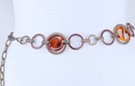 chain belt: alternating furrowed bronze and antique gold circles--larger circles have amber disk inset with oblique twist, all joined by double antique gold chain links which also form the extension chain tipped by tiny amber oval