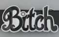 belt buckle with black lettered "Bitch" on white enamel
