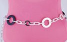 chain belt: big and small black and cream plastic rings bound by triple smooth white chain links; extension chain comprises furrowed silver right chain links tipped by tiny ball