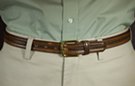 1-1/8" brown leather casual dress belt, distressed center with raised tubing on either side secured by single stitching; 1-1/2" by 1-1/2" brass finish buckle with single loop keeper