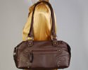 dark brown travelers shoulder bag with zippered side pockets and corner reinforcements