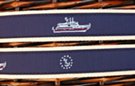 fabric web belt with leather tabs, antique gold-tone buckle, attached navy blue strip with embroidered yacht and commodore ensignia