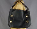 single-strap black duffle with rounded corners and vertically aligned big gold buttons