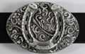 oval western belt buckle with horseshoe on foliage background
