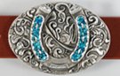 oval western belt buckle, horseshoe with inlay and foliage background