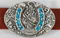 oval western belt buckle, horseshoe with inlay and foliage background