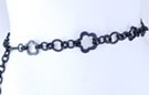 glossy chain belt, medium and small plum flowers, medium and small stippled circles, all joined by oval double links; smooth right chain extension tipped by small circle