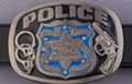 black and blue Police belt buckle, badge surrounded by cuffs and gun