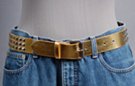 gold 1-1/2" leather strap belt with triple row of pyramid metal studs, rectangular roller buckle and leather retainer