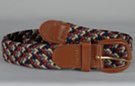 braided knitted stretch belt, braided from red, navy, beige, and grey chords, tan leather tabs and buckle