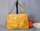 goldenrod double strap day bag with ornamental leatherette lace and reinforced corners reminiscent of buffalo skin messenger bags from the American west, zipper top, dual compartment lined interior