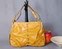 goldenrod double strap day bag with ornamental leatherette lace and reinforced corners reminiscent of buffalo skin messenger bags from the American west, zipper top, dual compartment lined interior