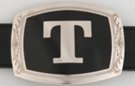 belt buckle with chrome initial "T" on black field